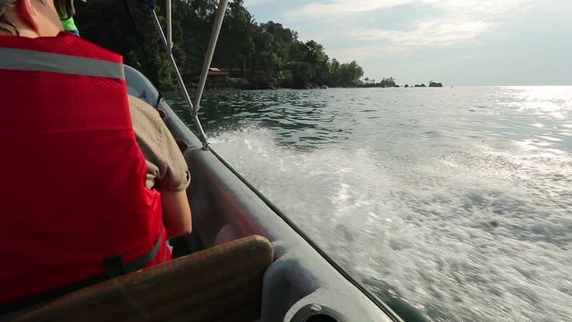 Splashing waves of a fast of a motorboat arriving to an exotic holiday location on the Pacific shore of Colombia