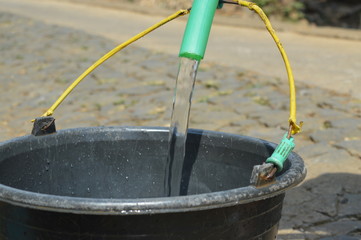 fill water into a bucket using a plastic hose