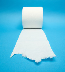 Torn off white toilet paper roll on minimalistic blue background