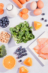 Foods that help maintain eyes healthy, products for keeping good vision. Black board with copy space, assortment of food for eye health on concrete background, flat lay, top view