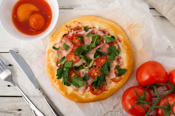 Homemade rustic pizza, with cutlery and with tomatoes
