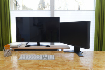 Moderner Arbeitsplatz zu Hause mit zwei Bildschirmen und einem Computer 