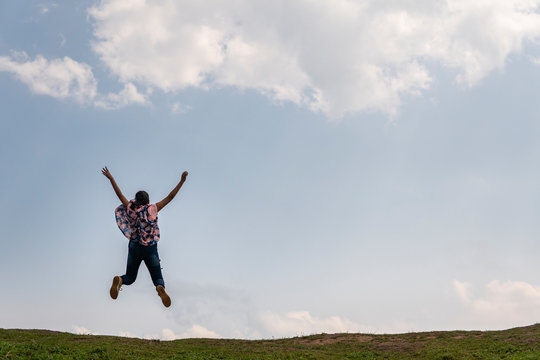Teenage girl jumping in a vast landscape