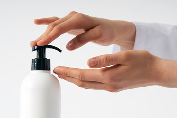 Woman hands pushing pump plastic soap bottle with copy space, using wash hand sanitizer gel pump...