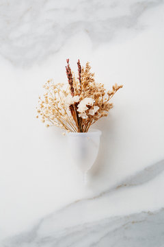 Menstrual cup containing dry flowers.