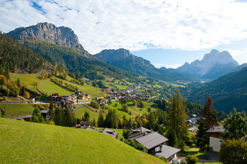 A village among green meadows and mountains. Italy.