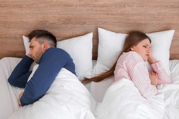 Sad couple after quarrel in bedroom