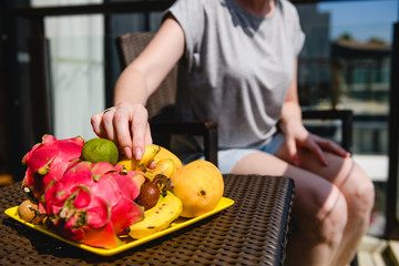 Female hand with many exotic fruits plate