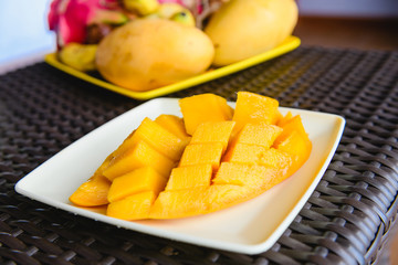 Chopped yellow juicy mango at white plate