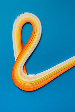 Multi colored quilling paper lying on colorful paper