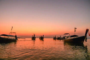 Fototapeta na wymiar Boats silhouettes at sea surface sunset light