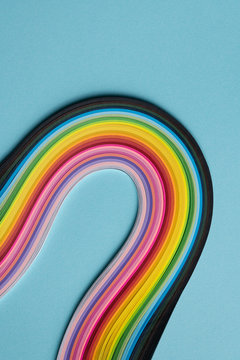Multi colored quilling paper lying on colorful paper
