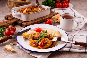 Chicken stew with vegetables on a white plate with a blue border. Dining table setting. Georgian cuisine - chakhokhbili.
