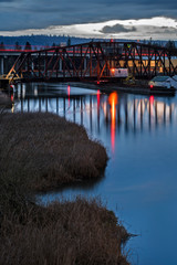 Rail Bridge and Highway with Light Trails over Grassy Waterway