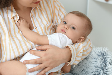 Happy mother with cute little baby at home