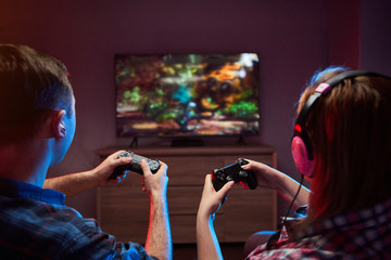 Portrait of crazy playful couple, Gamers enjoying Playing Video Games on Playstation indoors...