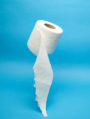 Torn off white toilet paper roll on minimalistic blue background
