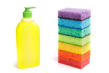 Bright multi-colored sponges and a plastic bottle of liquid for sanitary work, washing dishes,...