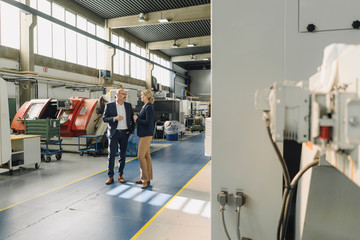 Businessman and businesswoman talking in a factory