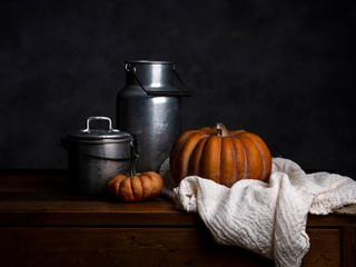 Pumpkin, tin cans and cloth on wood