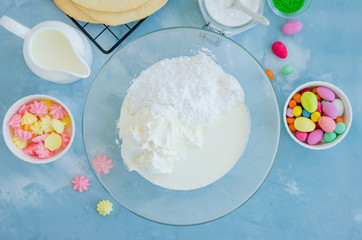 Recipe step by step. Step 5. Preparation of cream for Easter cake egg shaped. Bowl with cream cheese, cream and powdered sugar. Horizontal orientation. Top view. Easter concept.
