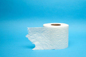Torn off white toilet paper roll on minimalistic blue background
