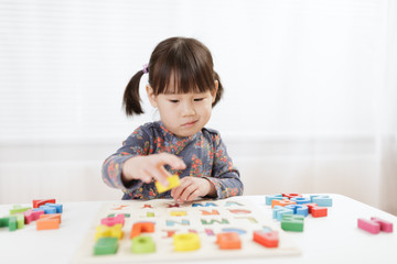 toddler girl learning letter blocks for homeschooling