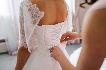 dress up the bride in a wedding dress with corset and lacing