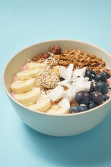Handmade Bowl healthy tasty breakfast of yogurt, smoothie with granola, nuts, bananas and berries