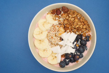 Handmade Bowl healthy tasty breakfast of yogurt, smoothie with granola, nuts, bananas and berries
