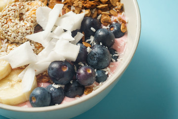 Handmade Bowl healthy tasty breakfast of yogurt, smoothie with granola, nuts, bananas and berries