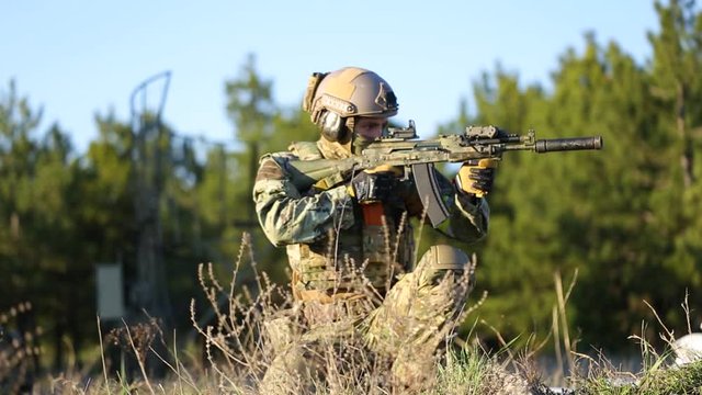 A soldier in full uniform aims their rifle at the enemy