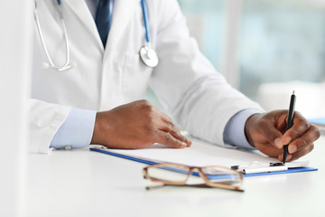 Fototapeta premium Male African-American doctor working in clinic, closeup