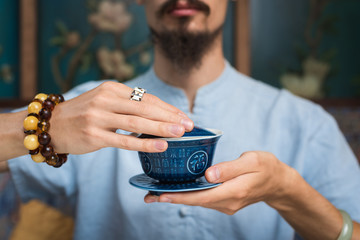  man holds in his hands a Chinese tea cup