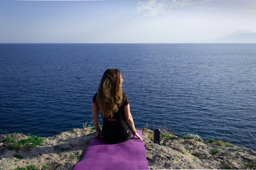 Beautiful young happy lonely girl watching the Mediterranean sea and relaxing