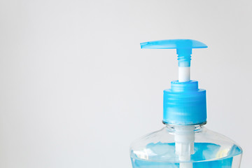 Fototapeta na wymiar Close up plastic bottle with blue cap. Liquid soap container with blue dispenser