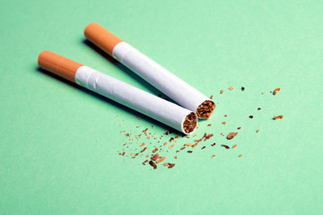 Two cigarettes on a green background
