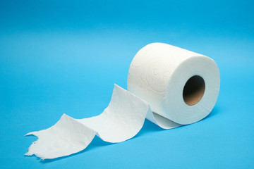 Torn off white toilet paper roll on minimalistic blue background