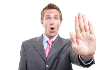 Businessman holding out a stop hand to keep away for social distancing against a white background