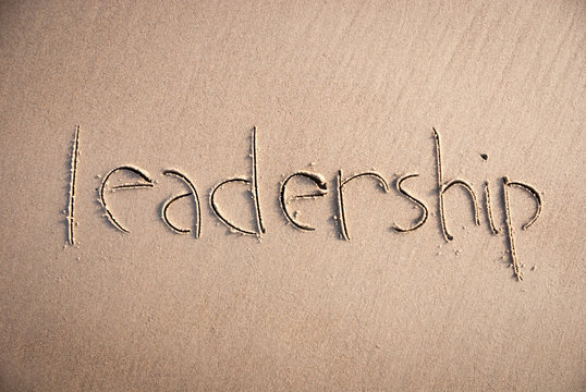 Handwritten message of leadership written in clean smooth sand