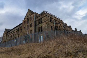 Fototapeta na wymiar The remains of the abandoned Hartwood Hospital, a 19th century psychiatric hospital with imposing twin clock towers located in Scotland. Recent filming location for the new Batman movie 