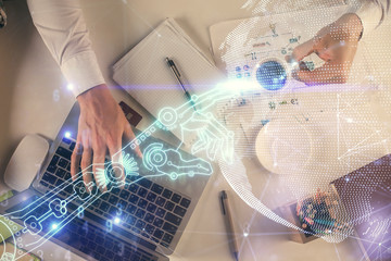 Double exposure of man's hands typing over computer keyboard and tech theme hologram drawing. Top view. Technology concept.