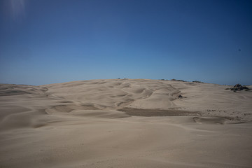 Sand dunes against blue sky