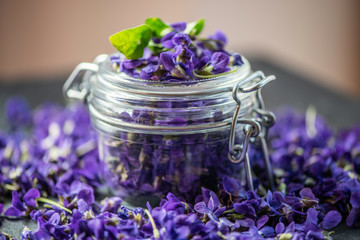 purple viola odorata violet flower heads in a glass jar 