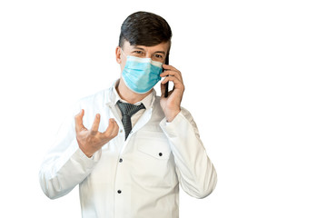 A young doctor in a white coat and a virus mask is talking on the phone. horizontal frame