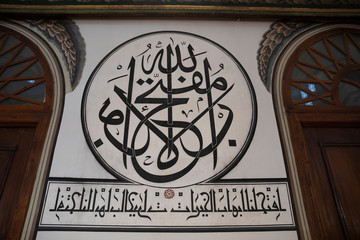 Bursa, Turkey - February 23, 2020: Islamic calligraphic writings between windows on wall of historical Ulu Cami (Grand Mosque) in Bursa.