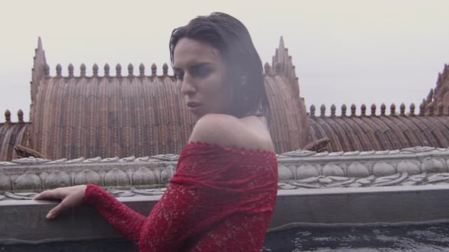 Woman In Red Dress Posing To Camera In Temple Pool