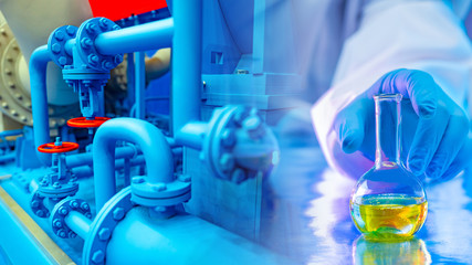 Pipes in the enterprise. Factory for the production of chemicals. Concept sample taken in production. In vitro fluid. Test tube with chemical fluid. A person reaches for the test tube. Industry