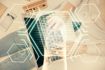 Fototapeta premium Double exposure of woman hands working on computer and fingerprint hologram drawing. Top View. Digital Security concept.