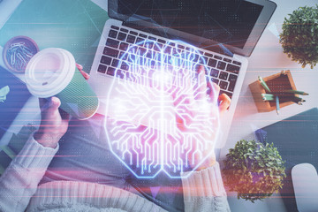 Double exposure of woman working on computer andhuman brain hologram drawing. Top View. Ai concept.